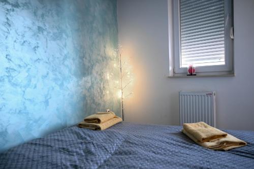a bedroom with a bed with two towels on it at Hanan Apartmani in Novi Pazar