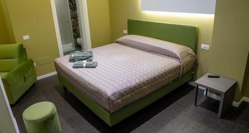 a bedroom with a bed with a green head board at Opera Hotel in Gravina in Puglia