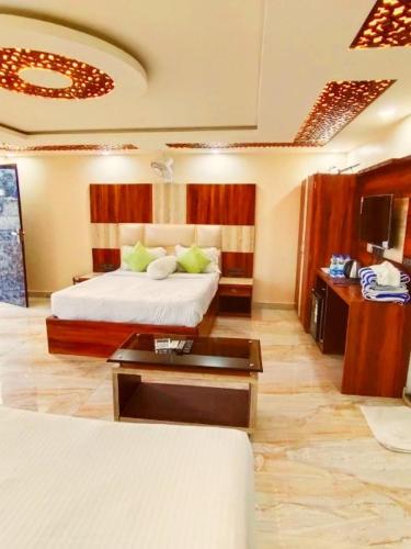 a hotel room with a bed and a coffee table at Red Rose Resort in Mandarmoni