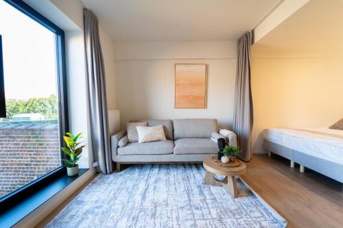 a living room with a couch and a bed at Fourstay Luxury City Apartments Diegem - Brussels in Diegem