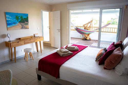 a bedroom with a bed with a hammock and a desk at Villa MangoKera in Saint-François