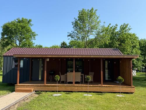 domek z tarasem w trawie w obiekcie Holiday Resort Zakątek Łeba w Łebie