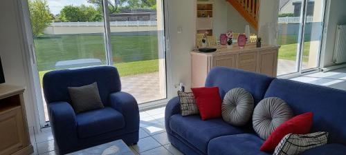 un salon avec un canapé bleu et une chaise dans l'établissement Gîte Portsallais, à Ploudalmézeau