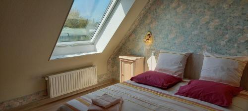 - une chambre avec un lit avec deux oreillers et une fenêtre dans l'établissement Gîte Portsallais, à Ploudalmézeau