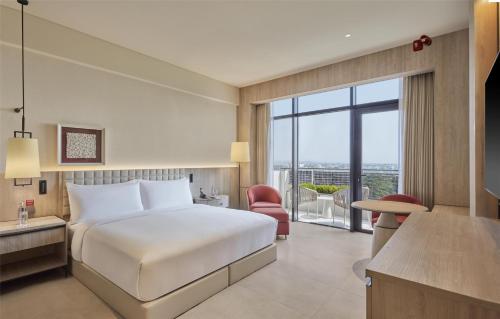 a hotel room with a bed and a balcony at Hilton Gurugram Baani City Centre in Gurgaon