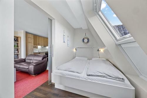 a white bedroom with a bed and a window at Resort Deichgraf Resort Deichgraf 27-21 in Wremen