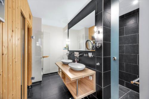 a bathroom with two sinks and a mirror at Resort Deichgraf Resort Deichgraf 31-13 in Wremen