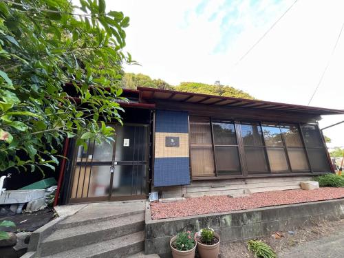 a small house with some plants in front of it at 鎌倉逗子の隠れ古民家宿ことり庵 in Zushi