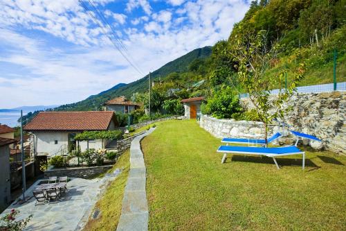 un patio con un banco azul en el césped en Casa Lumaca, en Cannero Riviera