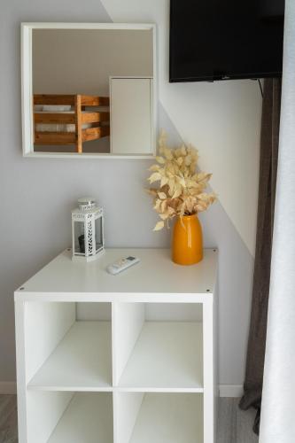 a white table with a vase of flowers on it at Villa Versilia in Lido di Camaiore