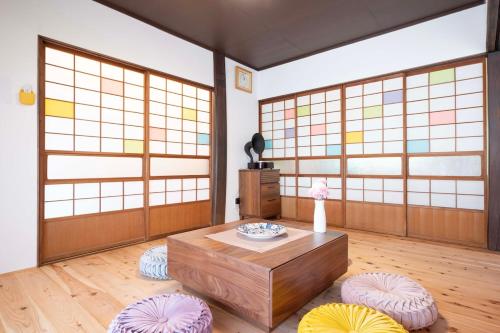a living room with a table and two stools at 鎌倉逗子の隠れ古民家宿ことり庵 in Zushi