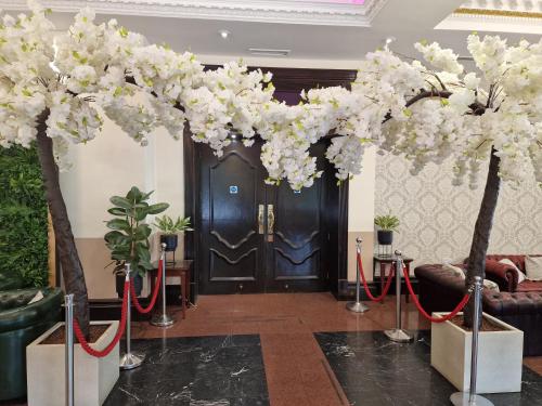 a lobby with a black door and white flowers at Royal Court Hotel & Spa Coventry in Coventry