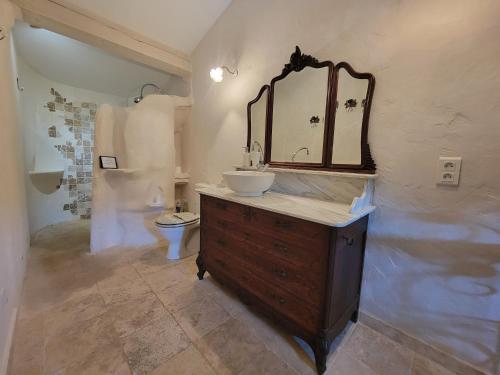 une salle de bain avec un lavabo et un miroir et des toilettes dans l'établissement Villa La Maurette Provenzalische Steinhaus - mitten in der Natur mit privatem Pool und Garten by Riviera HomeLife, à Roquebrune-sur Argens