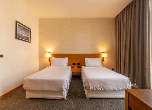 a hotel room with two beds and a table at The Vern at BLVD in Nashik