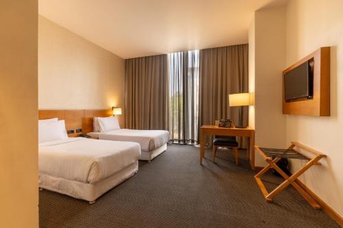 a hotel room with two beds and a television at The Vern at BLVD in Nashik