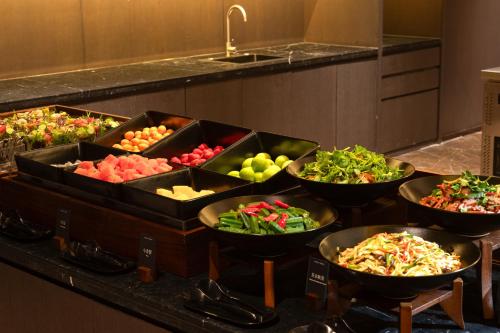 a buffet with bowls of different types of vegetables at Atour S Hotel Ziyang Metro Station Jin'an District Fuzhou in Fuzhou