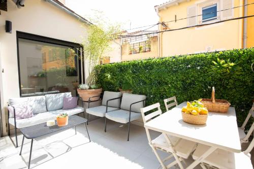 d'une terrasse avec un canapé, des chaises et une table. dans l'établissement Townhouse with terrace & parking in the heart of Old Antibes, à Antibes
