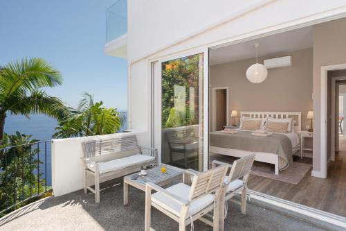 una camera da letto con un letto e un balcone di OurMadeira - Villa Aquarela, panoramic seaviews a Caniço