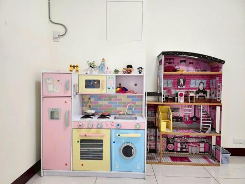 a room with a play kitchen with a toy stove and a refrigerator at 谷香 Guxiang House 東區靜巷透天獨棟 in Tainan