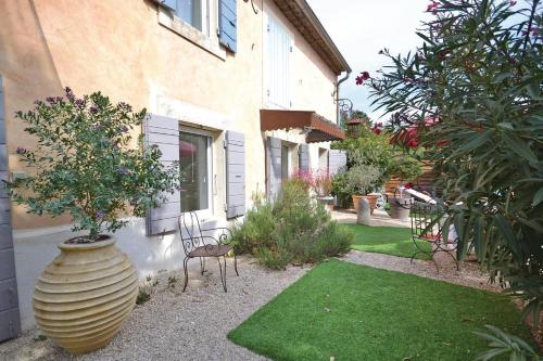 un grand vase avec un arbre dedans à côté d'une maison dans l'établissement Mas Bosca Brun, à Cheval-Blanc