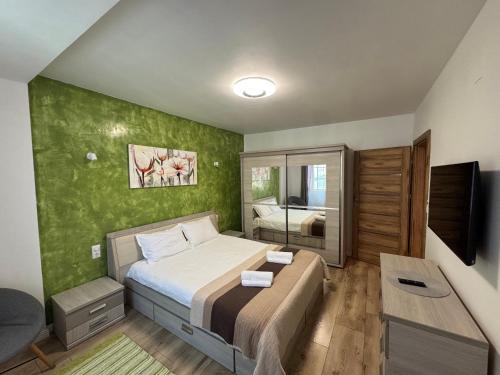 a bedroom with a bed and a television in it at Katy Boulevard Apartman in Satu Mare