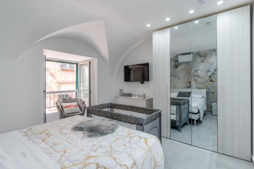 a white bedroom with a bed and a mirror at Casa Dolce Vita in Ventimiglia