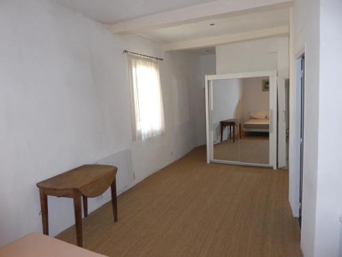 an empty room with a table and a mirror at Maison de Village in Puimoisson