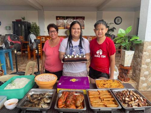 three women standing in front of a table of food at Julz Ridge Exclusive Place in Bayombong in Bayombong