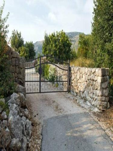 a stone fence with a gate and a stone wall at Holiday Home Lišnjak in Drniš
