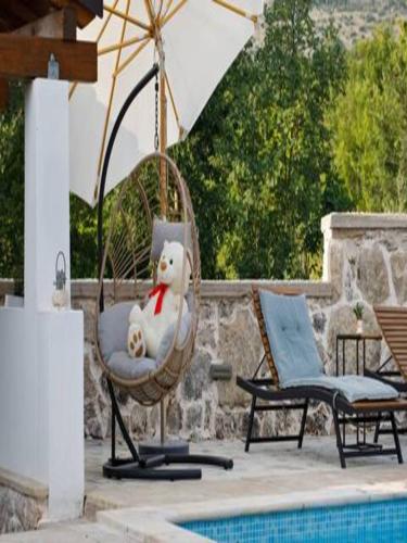 a teddy bear sitting in a chair next to a pool at Holiday Home Lišnjak in Drniš