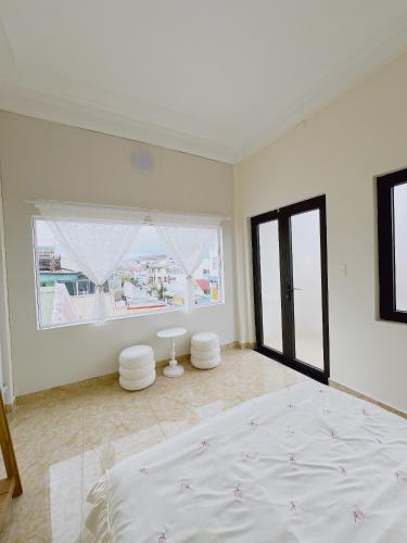 a white bedroom with a large bed and a window at Mập's Soul Hostel Đà Lạt in Da Lat