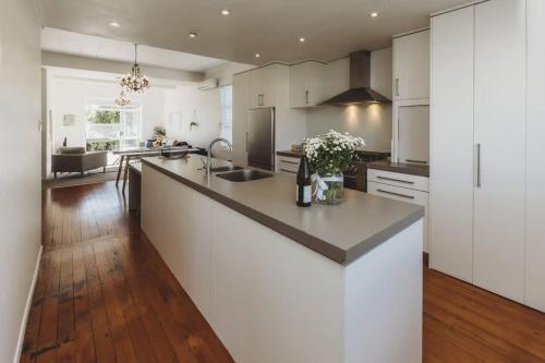 a kitchen with white cabinets and a large counter top at Ropiha Retreat - close to Fitzroy Beach paradise in New Plymouth