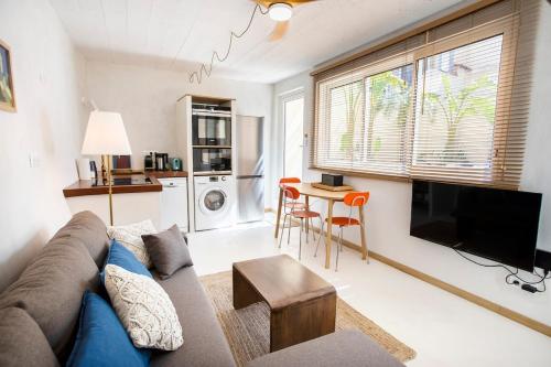 un salon avec un canapé, une télévision et une table dans l'établissement Le cabanon de Samatan, à Marseille