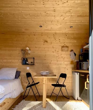 une chambre avec un lit, deux chaises et une table dans l'établissement La tiny house, à Saint-Vincent-de-Paul