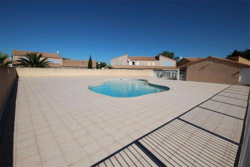 - une piscine sur une terrasse avec une maison dans l'établissement Belle Maison toute climatisee -veranda -4 couchages, Exposition ouest-sud- 800M DE LA MER DE PORTIRAGNES PLAGE LRCS169, à Portiragnes