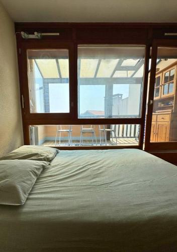 - une chambre avec un lit et une fenêtre avec des chaises dans l'établissement SABORDS - Studio au port de Capbreton, à Capbreton
