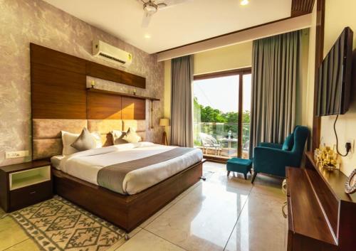 a bedroom with a large bed and a blue chair at Luxury 3BHK Appartment With Fully equipped Kitchen and Balcony in Sohāna