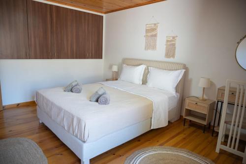 a bedroom with a white bed and a wooden floor at Galinos-traditional house B in Eresos
