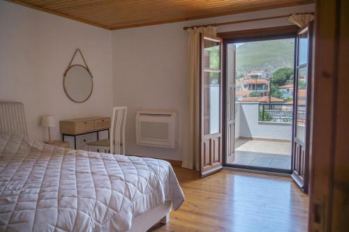 a bedroom with a bed and a door to a balcony at Galinos-traditional house B in Eresos