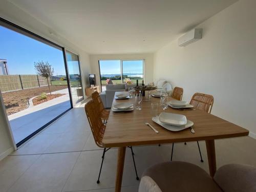 une salle à manger avec une table et des chaises en bois dans l'établissement Villa 6 people, Spa and Sea View, à Carantec