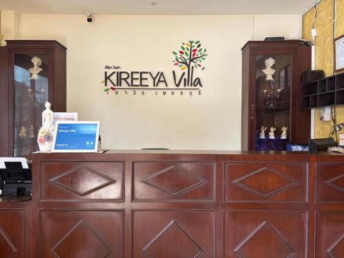 a reception desk with a laptop on top of it at Kireeya Villa in Phetchaburi