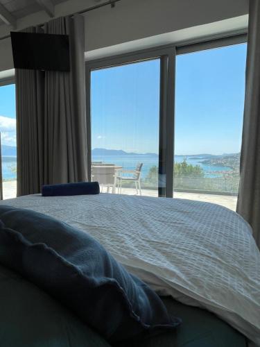 a bedroom with a bed with a view of the ocean at Villa Pétra in Katouna