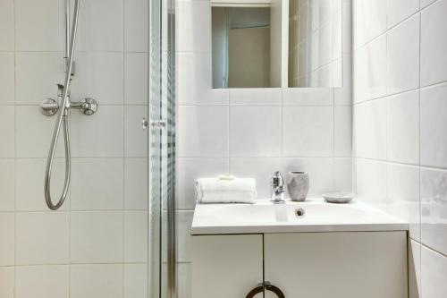 une salle de bain blanche avec un lavabo et une douche dans l'établissement Apartment Chamois Blanc 1 - Central Chamonix Haven, à Chamonix-Mont-Blanc