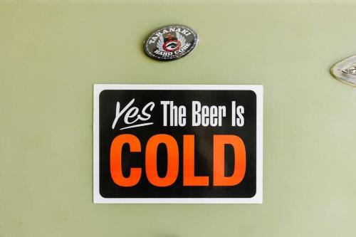 a sign on a wall with the words the bacon is cold at Messenger Magic - classic 5BR Kiwi bach in Oakura