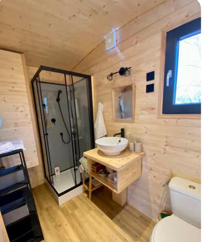 La salle de bains est pourvue d'un lavabo et d'une douche. dans l'établissement La tiny house, à Saint-Vincent-de-Paul