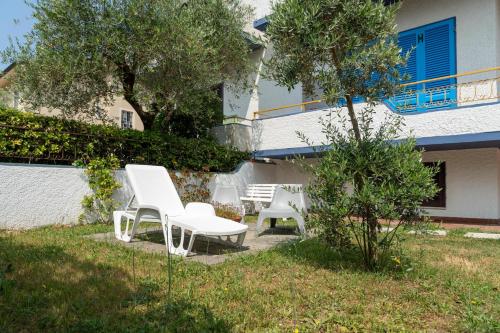 a group of white chairs sitting in a yard at Villa Versilia in Lido di Camaiore