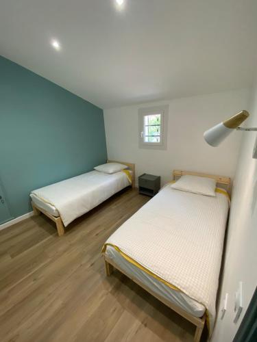 Ce lit se trouve dans un dortoir doté de murs bleus et de parquet. dans l'établissement Maison Aix-en-Provence, à Aix-en-Provence