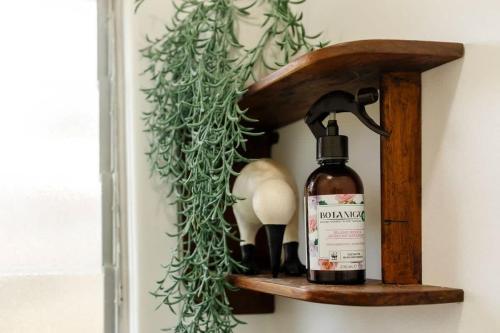 a bottle of alcohol sitting on a wooden shelf at Messenger Magic - classic 5BR Kiwi bach in Oakura