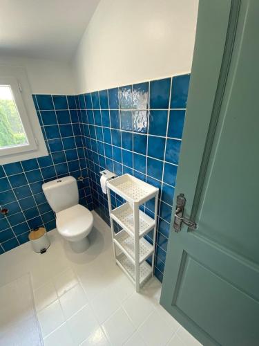 La salle de bains est pourvue de toilettes et d'un mur carrelé bleu. dans l'établissement Maison Aix-en-Provence, à Aix-en-Provence