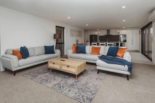 a living room with two couches and a coffee table at Bell Block Beauty - pristine 3BR home near beach in New Plymouth
